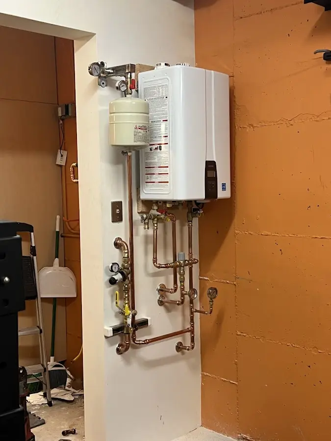 Plumbing technician inspecting water heater connections in Hahnville